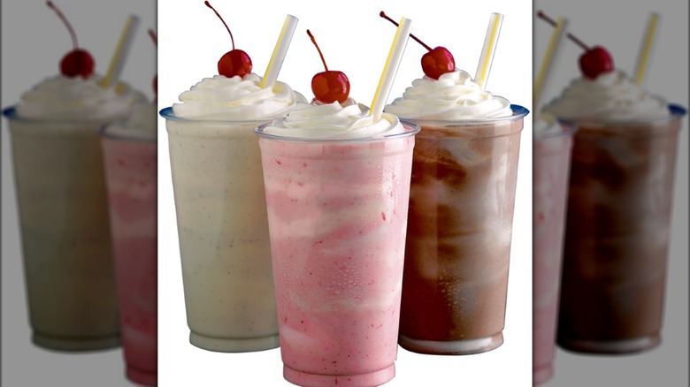 Three milkshakes with cherries on top