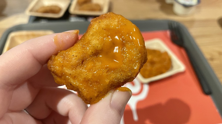 hand holds up Wendy's Spicy Buffalo Saucy Nuggs