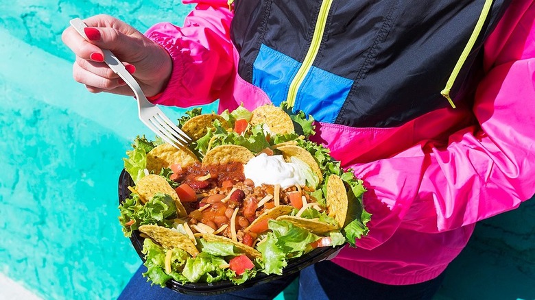 Person holding a taco salad