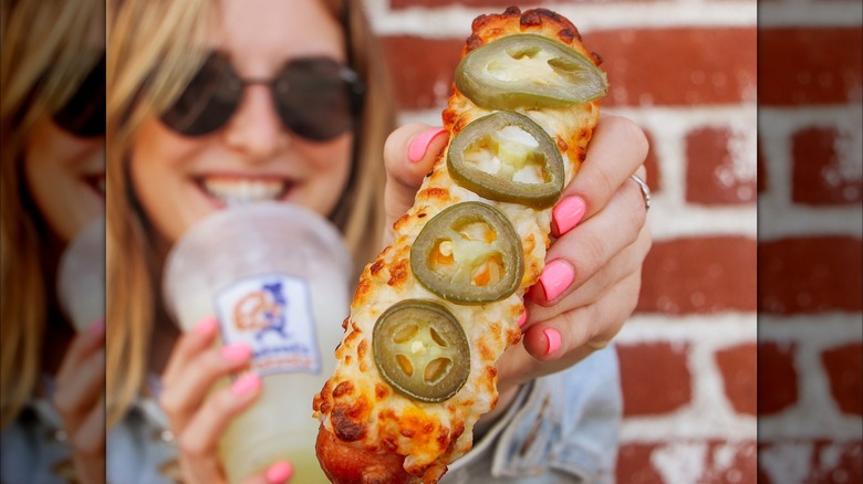 woman holding jalapeño cheese dog