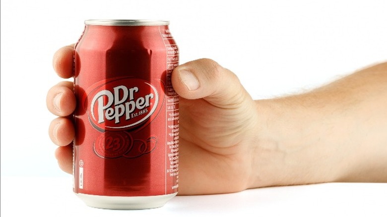 Hand holding can of Dr. Pepper