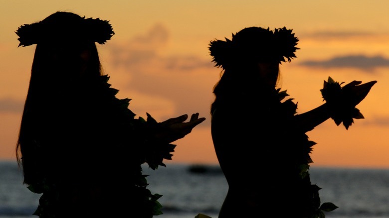 Silhouette of hula dancers on beach