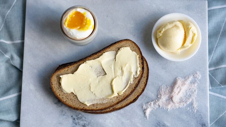 Rye bread, soft boiled egg, and butter