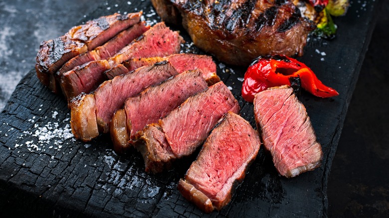 sliced wagyu beef on charred wood