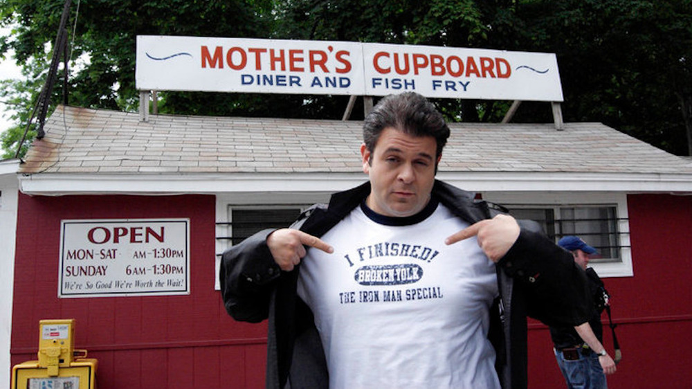 Adam Richman in front of restaurant