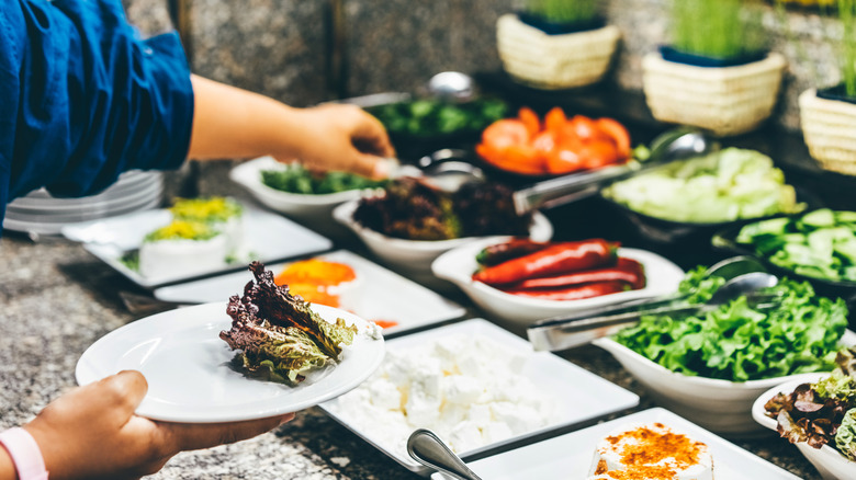 Person taking food from buffet