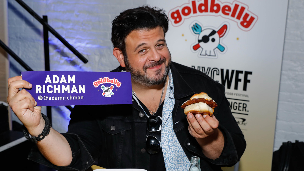 Adam Richman holding a sandwich