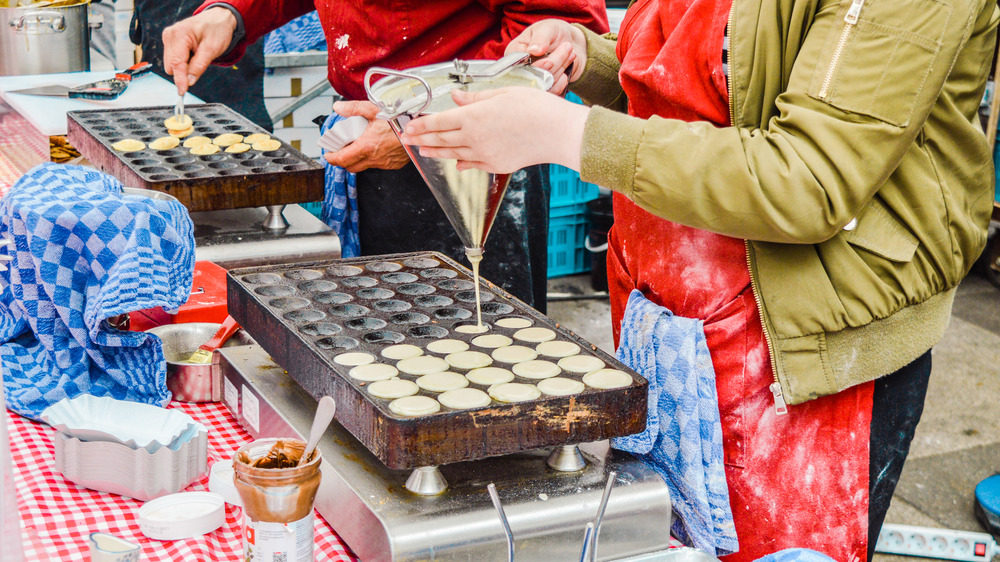 Person making poffertjes in a mould