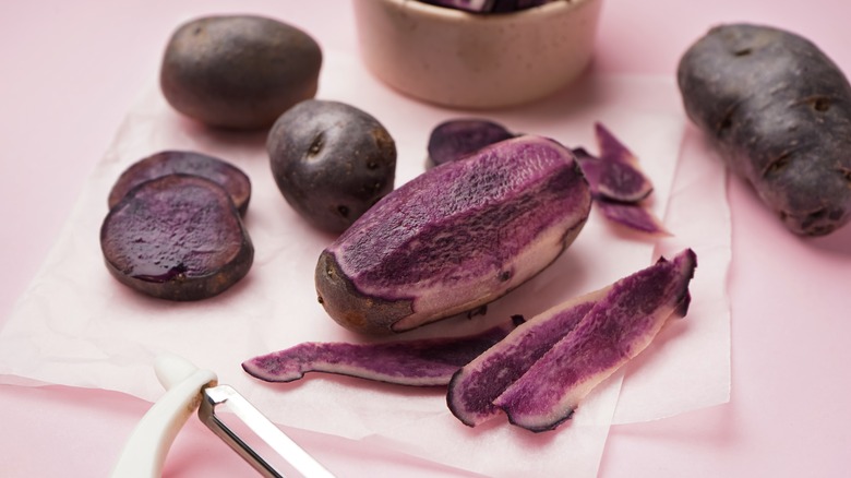 purple potatoes and peels on board