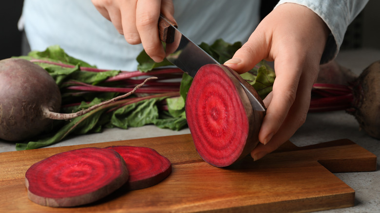 woman cutting fresh red beet