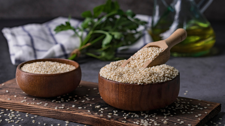 Raw sesame seeds in two wooden bowls