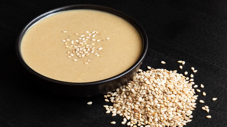 A bowl of tahini with raw sesame seeds