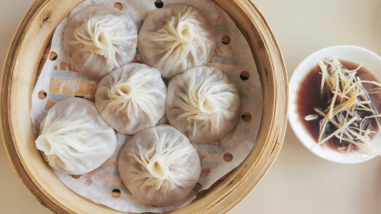 soup dumplings in basket with sauce