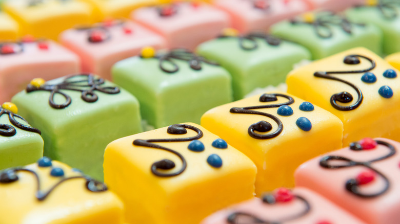 Pink, green, and yellow petit four cakes