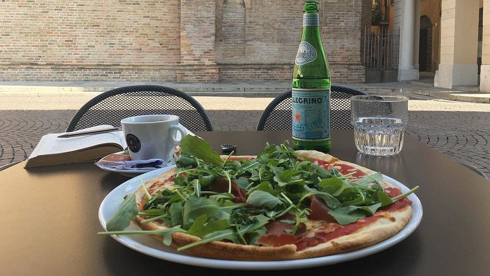 Breakfast pizza topped with arugula