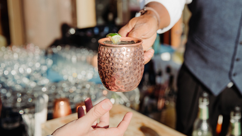 Bartender handing a customer a Moscow Mule