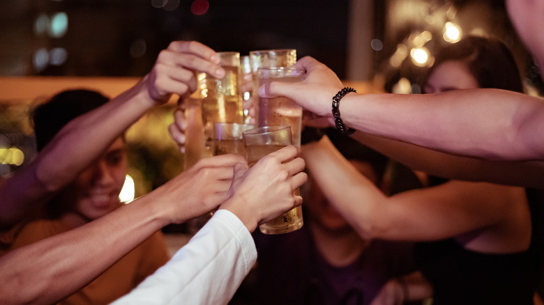 friends with drinks clinking glasses