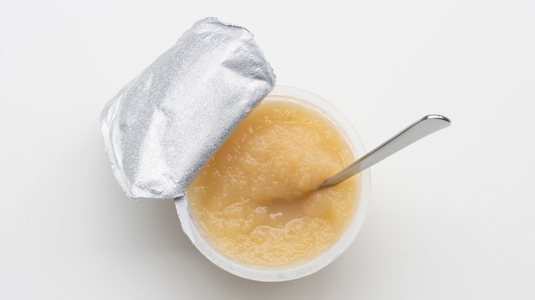 applesauce in plastic cup with spoon