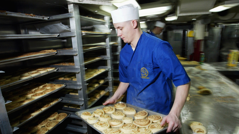 US Navy chef preparing trays of cinnamon rolls