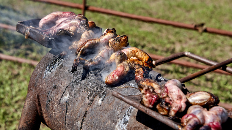 calf testicles cooking on a charcoal burner