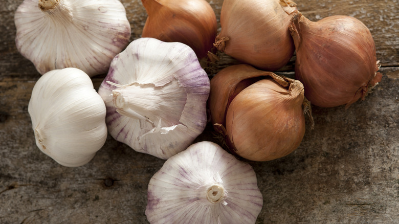 onions and garlic on wood 