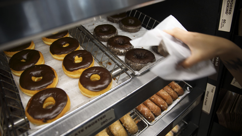 Dunkin' employee holding donut 