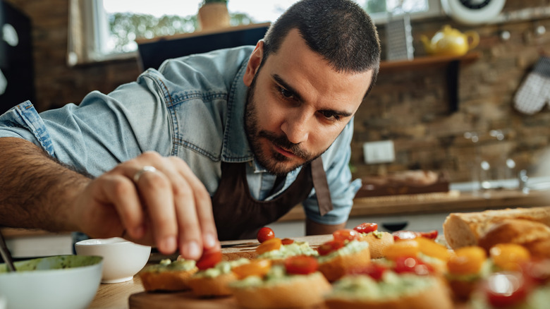 chef in home kitchen making bruschetta