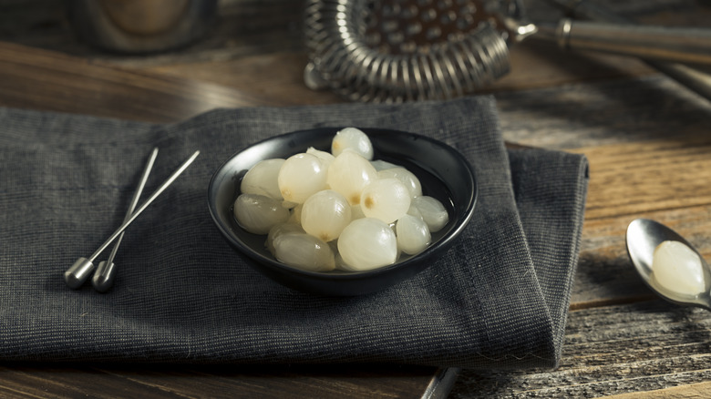 Bowl of cocktail onions on black napkin