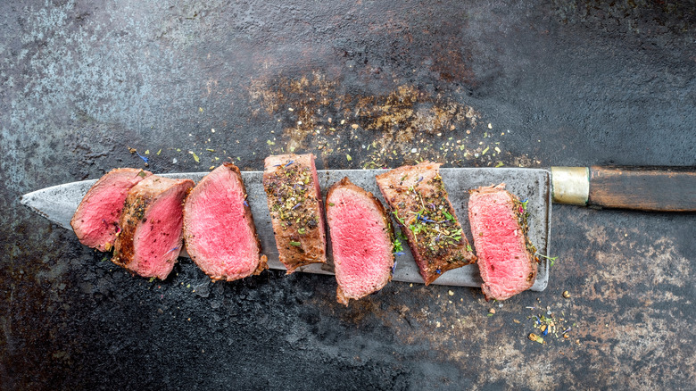 sliced backstrap arranged on knife