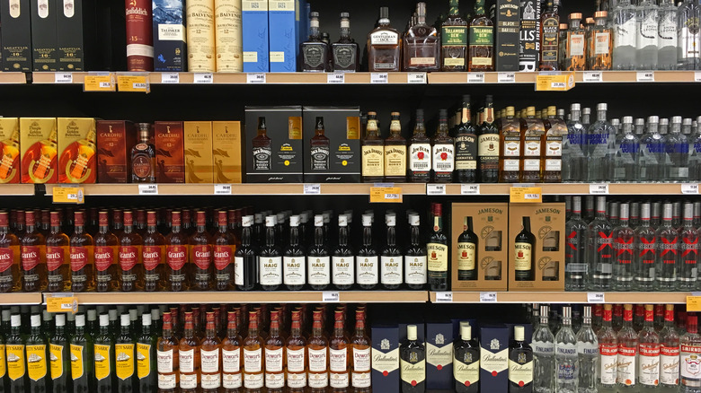 different whiskey bottles lined up on shelves