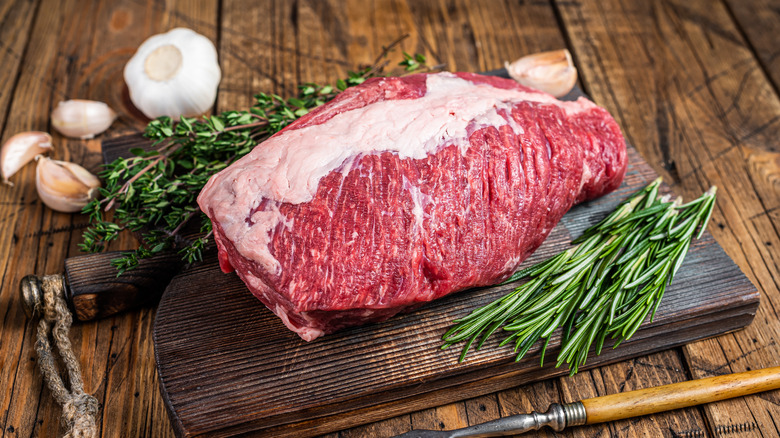 Whole raw brisket on a cutting board