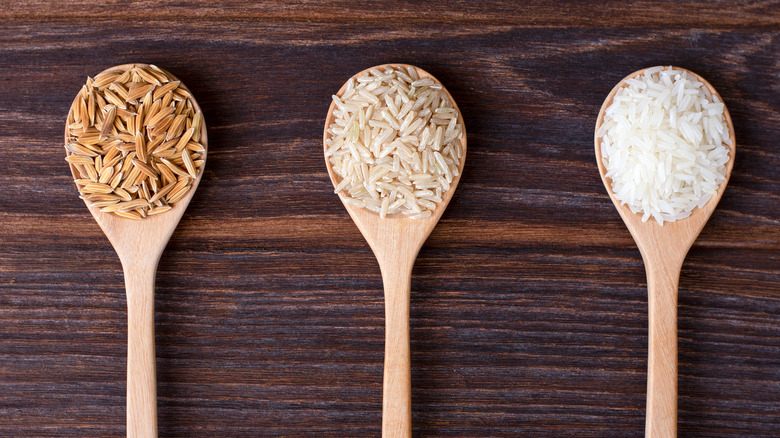 Spoons with brown, converted, and white rice