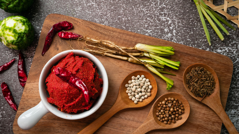 cup of red curry paste on cutting board