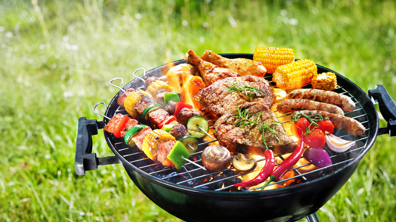 Outdoor grill with kabobs and meat