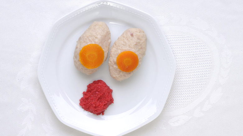 Gefilte fish on a plate with horseradish