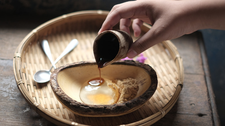 pouring kuromitsu on raindrop cake