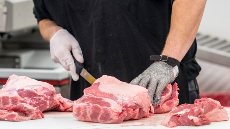 Person slicing meat with knife