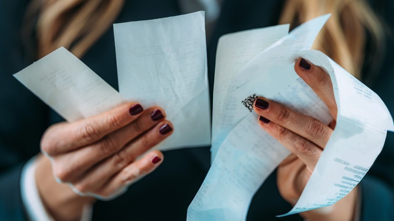 woman holding many receipts