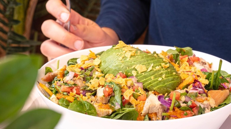 person eating avocado bowl