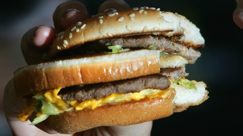 hand holding double decker burger