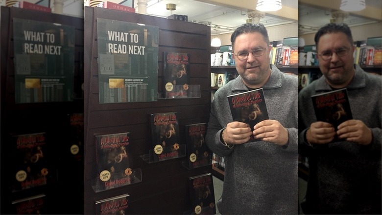 David Ruggerio holding one of his horror novels in bookstore