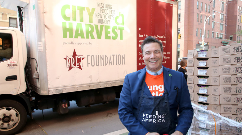 Rocco DiSpirito standing in front of a City Harvest truck