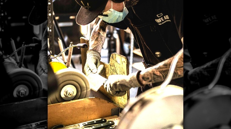 worker sharpening knife at knife aid