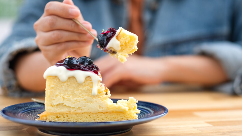 Person eating a slice of cake