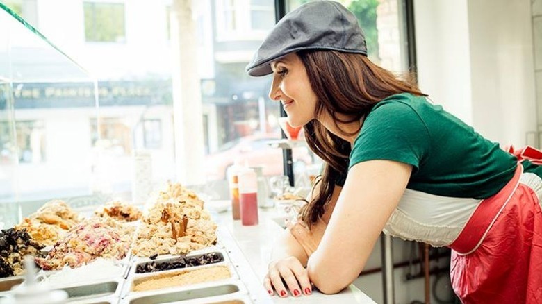 Sarah Schulz leaning over bread pudding prep station