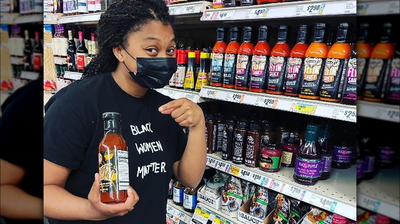 Tyla-Simone Crayton holding Sienna Sauce at a grocery store