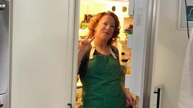 Ashley Moore in front of fridge throwing up peace sign