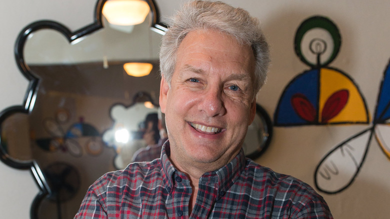 Marc Summers grinning in a plaid shirt