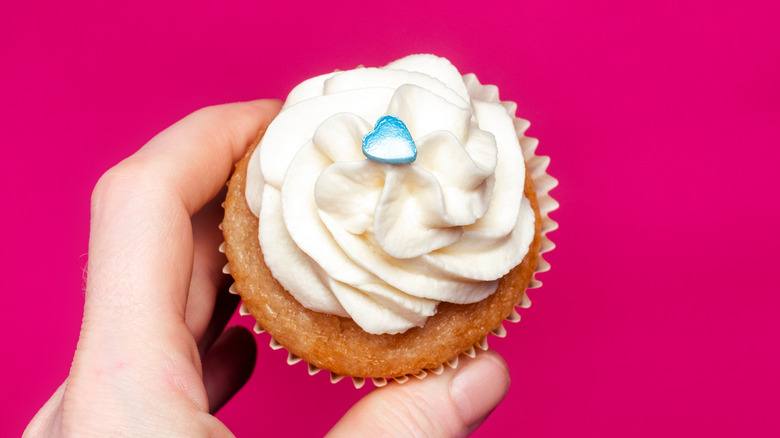 A person holding a cupcake