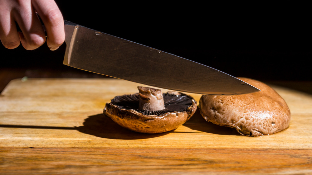 A chef cutting portobello mushrooms